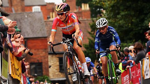 Female road cyclists ascend a hill