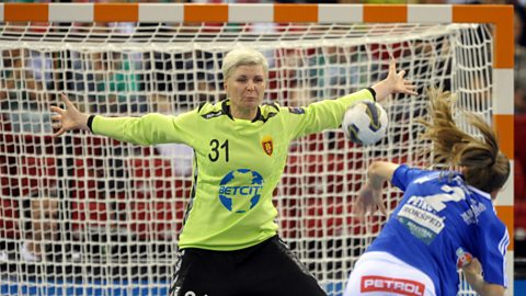 A handball goalkeeper aims to stop the ball getting past her