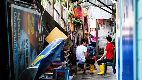 Glenn Sundeen/Getty Market workers take a social break in a Bangkok alley (Credit: Glenn Sundeen/Getty)