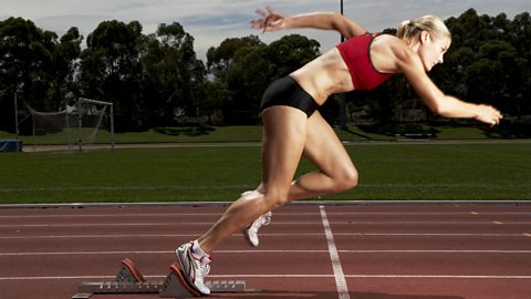 Female runner leaving starting blocks on the track