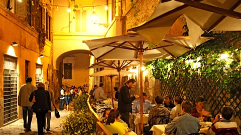 Franz Marc Frei/Alamy Enjoying a meal on the terrace of a restaurant in Rome's Trastevere neighbourhood (Credit: Franz Marc Frei/Alamy)