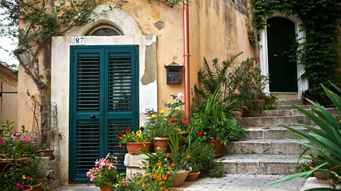 Thibaut Petit-Bara/Alamy Flowers line the steps of an old Sicilian home (Credit: Thibaut Petit-Bara/Alamy)