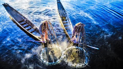 The local fishermen are fishing in unique style. The standing on the single  timber pole can only found in this Indian ocean Stock Photo - Alamy