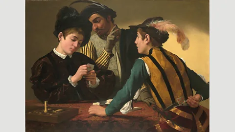 Wikimedia Commons Caravaggio’s Cardsharps from around 1595 shows two swindlers trying to dupe a boy at a game of cards (Credit: Wikimedia Commons)