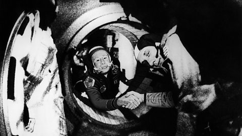 Image of American astronaut Thomas Stafford and Russian cosmonaut Aleksey Leonov shaking hands in space in 1975.