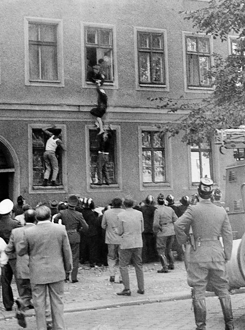 A photograph of 77-year-old East Berliner Frieda Schulze escaping out of her apartment window to the western part of Berlin.