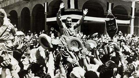 Photo of the Egyptian Prime Minister Gamel Abdel Nasser being carried through the streets of Port Said after the British evacuation.