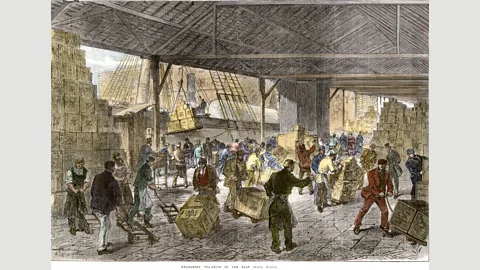 North Wind Picture Archives/Alamy Workers unload tea ships in London’s East India Company docks in the mid-19th Century (Credit: North Wind Picture Archives/Alamy)