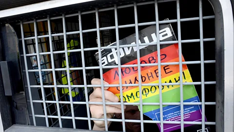 Getty Images A Russian LGBT rights activist inside a riot police van during a rally in Moscow in 2013 (Credit: Getty Images)