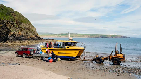 Pearl Bucknall/Alamy Visitors board Colin Evans’ boat at Porth Meudwy (Credit: Pearl Bucknall/Alamy)