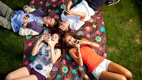 Teenagers using mobile phone and laughing