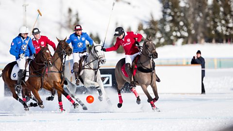 Members of the 'Cartier' team battle for the ball with team 'BMW' during the final of the Snow Polo World Cup