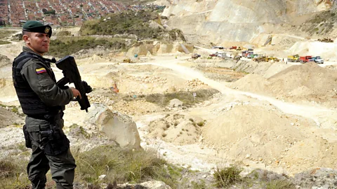 Getty Images Demand for sand has led to the emergence of illegal mining of the material – here, a police officer stands guard in a quarry near Bogota, Colombia (Credit: Getty Images)