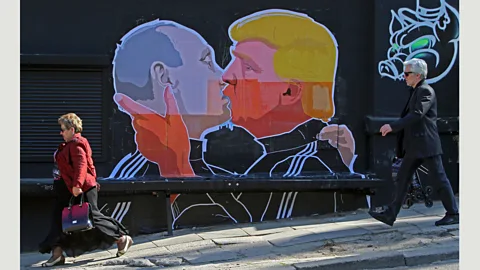 Petras Malukas/AFP/Getty Images A new mural by the Lithuanian artist Mindaugas Bonanu shows Donald Trump and Vladimir Putin in a passionate embrace (Credit: Petras Malukas/AFP/Getty Images)