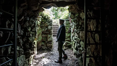 Amanda Ruggeri Standing in the tunnel’s entrance, archaeologist James Gossip peers back into Halliggye Fogou (Credit: Amanda Ruggeri)