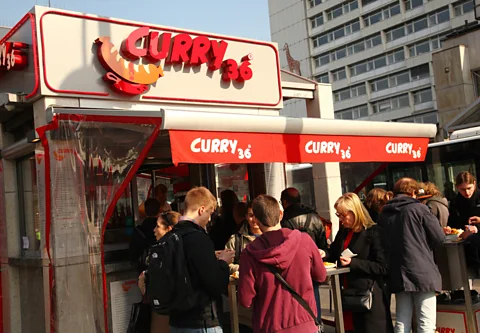 DPA Picture Alliance/Alamy Standing and chatting with strangers is part of the currywurst experience (Credit: DPA Picture Alliance/Alamy)