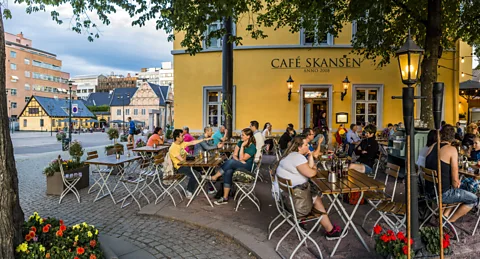 Maremagnum/Getty People enjoy fresh air at an outdoor cafe in Oslo (Credit: Maremagnum/Getty)