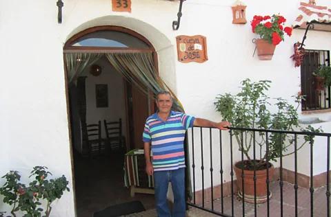 Esme Fox José standing outside the front door of his cave dwelling (Credit: Esme Fox)
