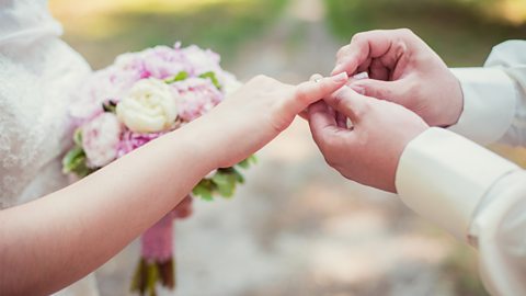 Groom putting a ring on his wife's finger