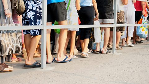 Legs of people standing in line one after another