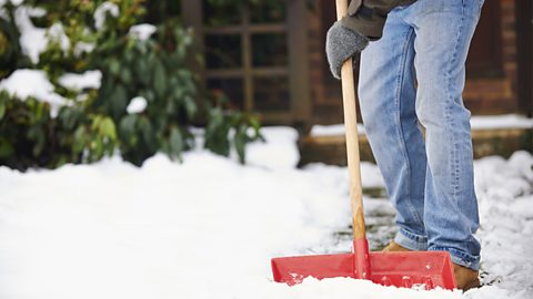 Man clearing snow from path with shovel