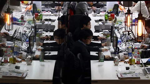 Tomohiro Ohsumi/Bloomberg/Getty Images Workers reflected in a glass door inside Tech Temple, a co-working space for start-ups  in Beijing (Credit:Tomohiro Ohsumi/Bloomberg/Getty Images)