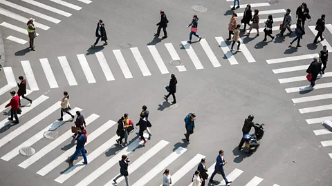 Getty Images Pedestrians cross a street in downtown Shanghai (Credit: Getty Images)