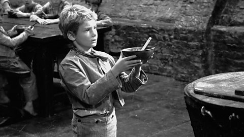 Mark Lester playing Oliver Twist holds up an empty bowl in the 1968 film adaptation of the Charles Dickens' novel