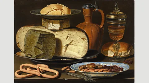 Mauritshuis A distorted reflection of a figure thought to be Clara Peeters can be seen in the metal lid of the jug in her Still Life with cheeses, Almonds and Pretzels (Credit: Mauritshuis)
