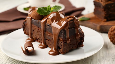 A piece of chocolate cake with mint on a table