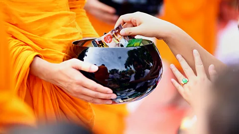 PHYO MG MG/AFP/Getty Images A Buddhist monk receives alms (Credit: PHYO MG MG/AFP/Getty Images)