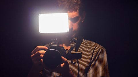 A DSLR operator using an LED light