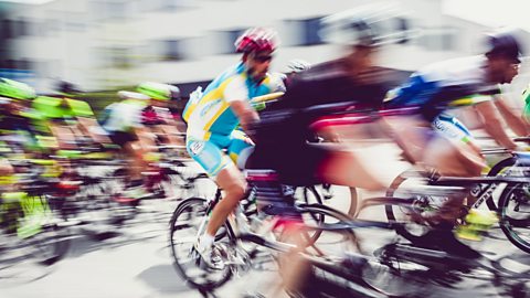 Motion blur from cyclists passing a camera lens at speed