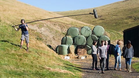 A boom operator using a boom pole