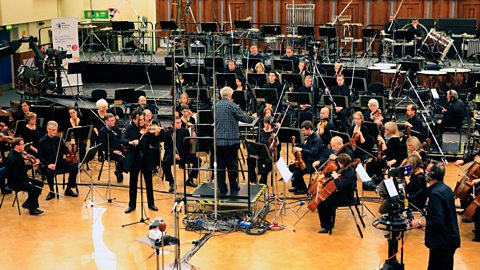 An orchestra recording a musical score