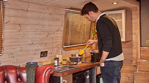 Tom Watkins Ryan Bateman cooks in the modern, stainless-steel kitchen aboard his houseboat (Credit: Tom Watkins)