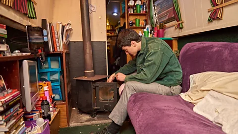 Tom Watkins Winters lights a fire in his stove; the space is cosy, but peaceful (Credit: Tom Watkins)
