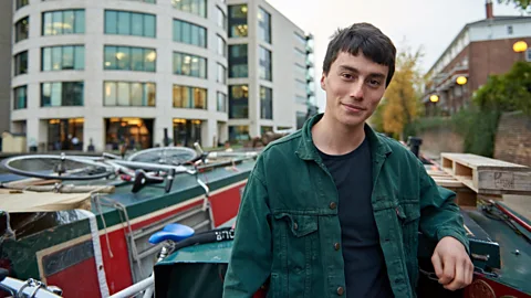 Tom Watkins Matthew Winters stands on his houseboat, which has allowed him to live in some of London’s priciest postcodes in the last two years (Credit: Tom Watkins)