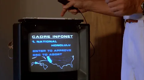 Braveworld/TriStar Schwarzenegger’s attempt to buy a flight to Hawaii using something called the Infonet (Credit: Braveworld/TriStar)