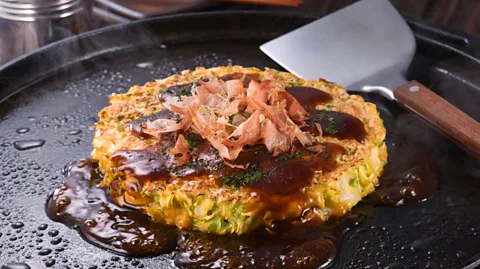 MIXA/Alamy The relaxed attitude in Osaka extends to the city’s food, exemplified in the messy okonomiyaki (Credit: MIXA/Alamy)