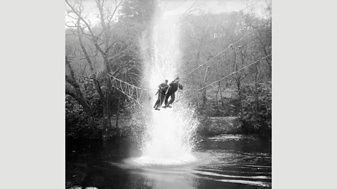 Imperial War Museum British Commandos cross a river under simulated artillery fire at a training school in Achnacarry, Scotland, in January 1943 (Credit: Imperial War Museum)