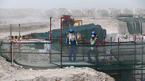 Getty Images Foreign laborers work at the construction site of a football stadium in Qatar in 2015 (Credit: Getty Images)