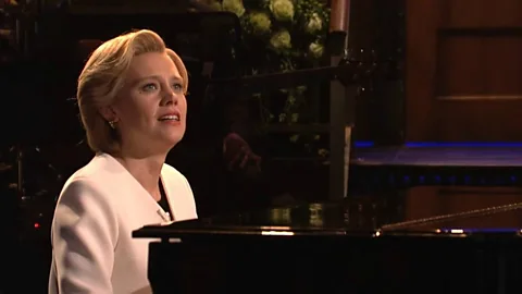 NBC After Trump’s election, some comedians turned somber, such as when Kate McKinnon, as Hillary Clinton, sang Hallelujah on Saturday Night Live (Credit: NBC)
