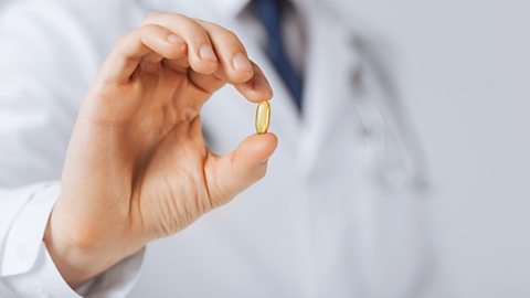 Doctor's hand holding a capsule