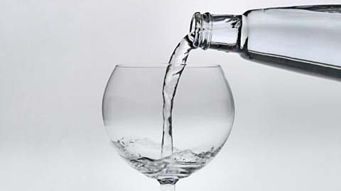 Water being poured from a bottle into a glass