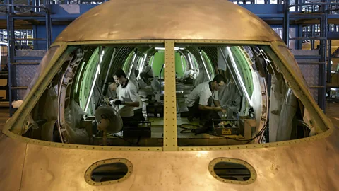 Getty Images Brazilian technicians assemble an aircraft at the production line of Embraer (Credit: Getty Images)