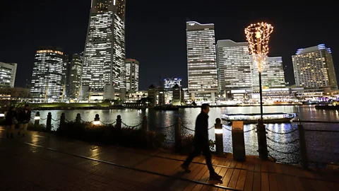 Getty Images Despite the late hour and darkness, it's likely many are working inside these well-lit Tokyo buildings (Credit: Getty Images)