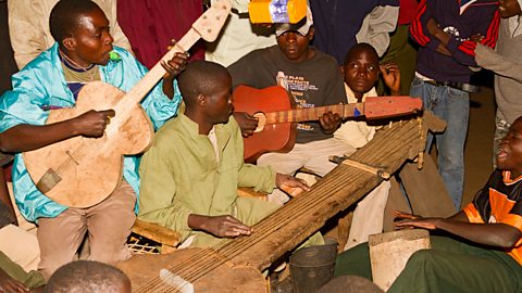 Men playing music at a party in an African village