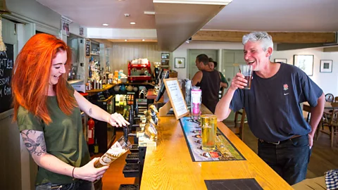 Plunkett Foundation A local is served at the 400-year-old Seven Stars pub near Oxford; it closed in 2012 and was reopened by the community in 2013 (Credit: Plunkett Foundation)
