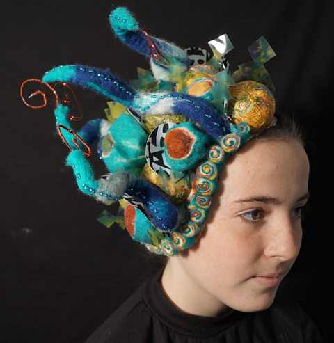 Student headpiece featuring different textures including paper and felt